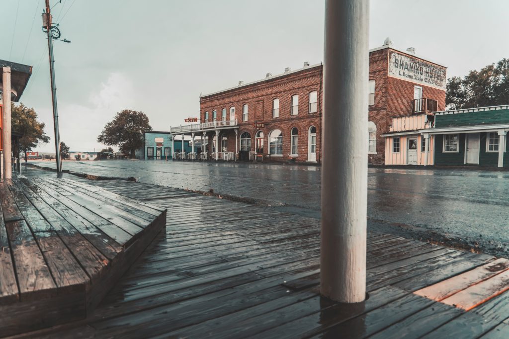 Empty boardwalk in abandoned ghost town showing closed businesses and weathered storefronts